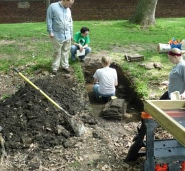 Archaeology workers dig in a trench on the Study grounds
