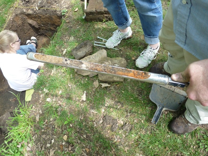 Archaeology worker demonstrates a core sample