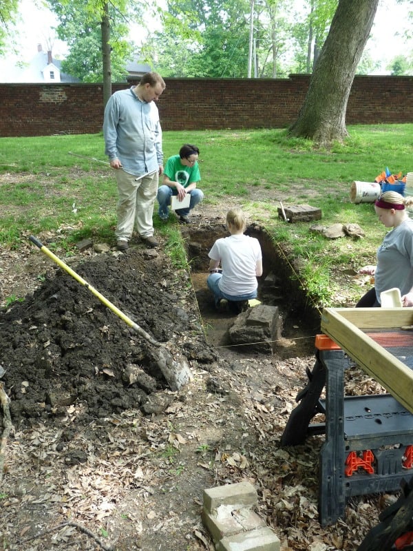 Archaeology workers dig in a trench on the Study grounds
