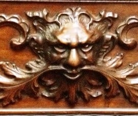 Close-up of the green-man carving on a wooden rocking chair