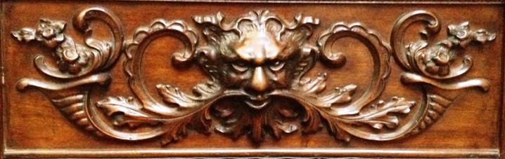 Close-up of the green-man carving on a wooden rocking chair