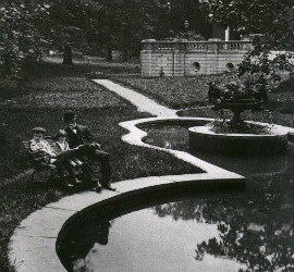Lew Wallace and his grandsons sit on a bench next to his reflecting pool