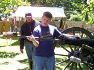 A participant learns to load a cannon in our Civil War encampment