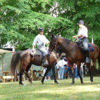 Civil War Cavalry reenactors on horseback in encampment