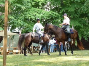 Civil War Cavalry reenactors on horseback in encampment