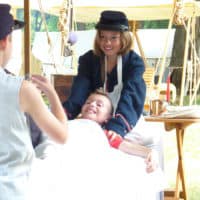 Civil War reenactors portray a medical tent in encampment