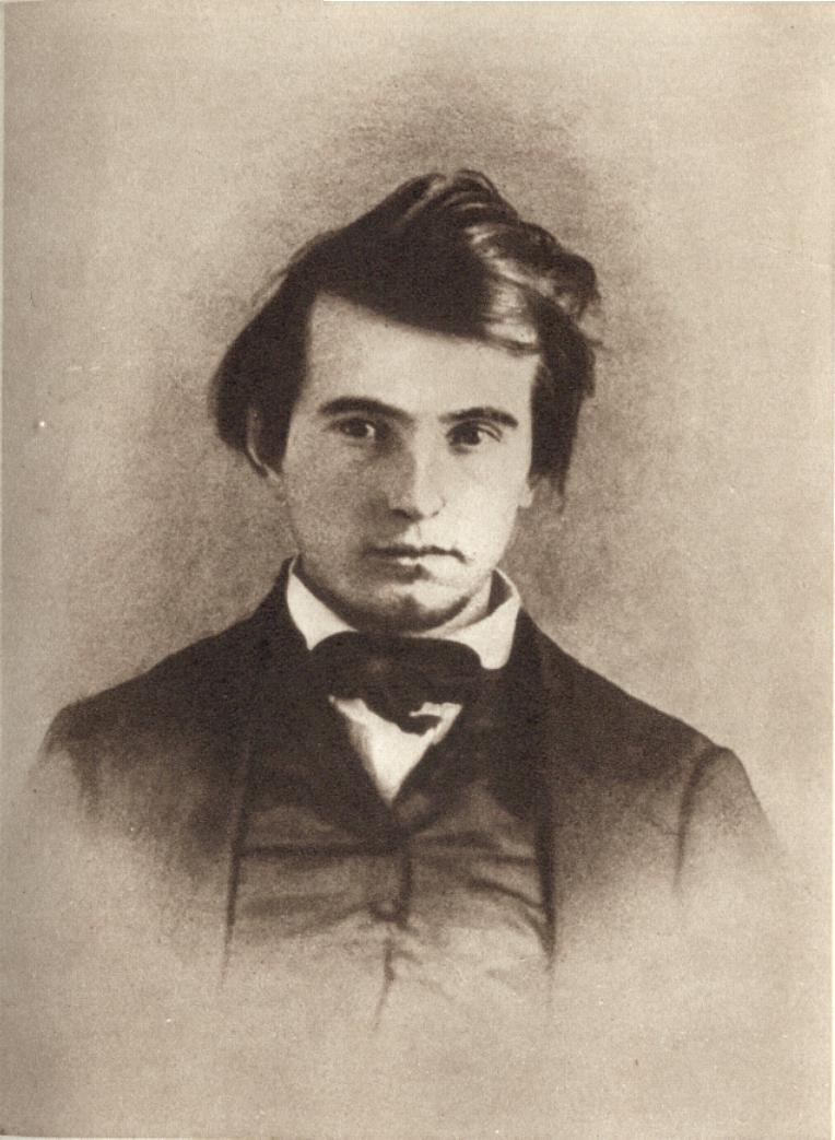 Lew Wallace as a young man. He has tousled dark hair and wears a dark suit. He looks directly at the camera.