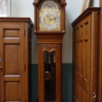 A grandfather clock commissioned from Tiffany and Company. It is made of quarter-sawn white oak and stands in a corner of the Stuy.