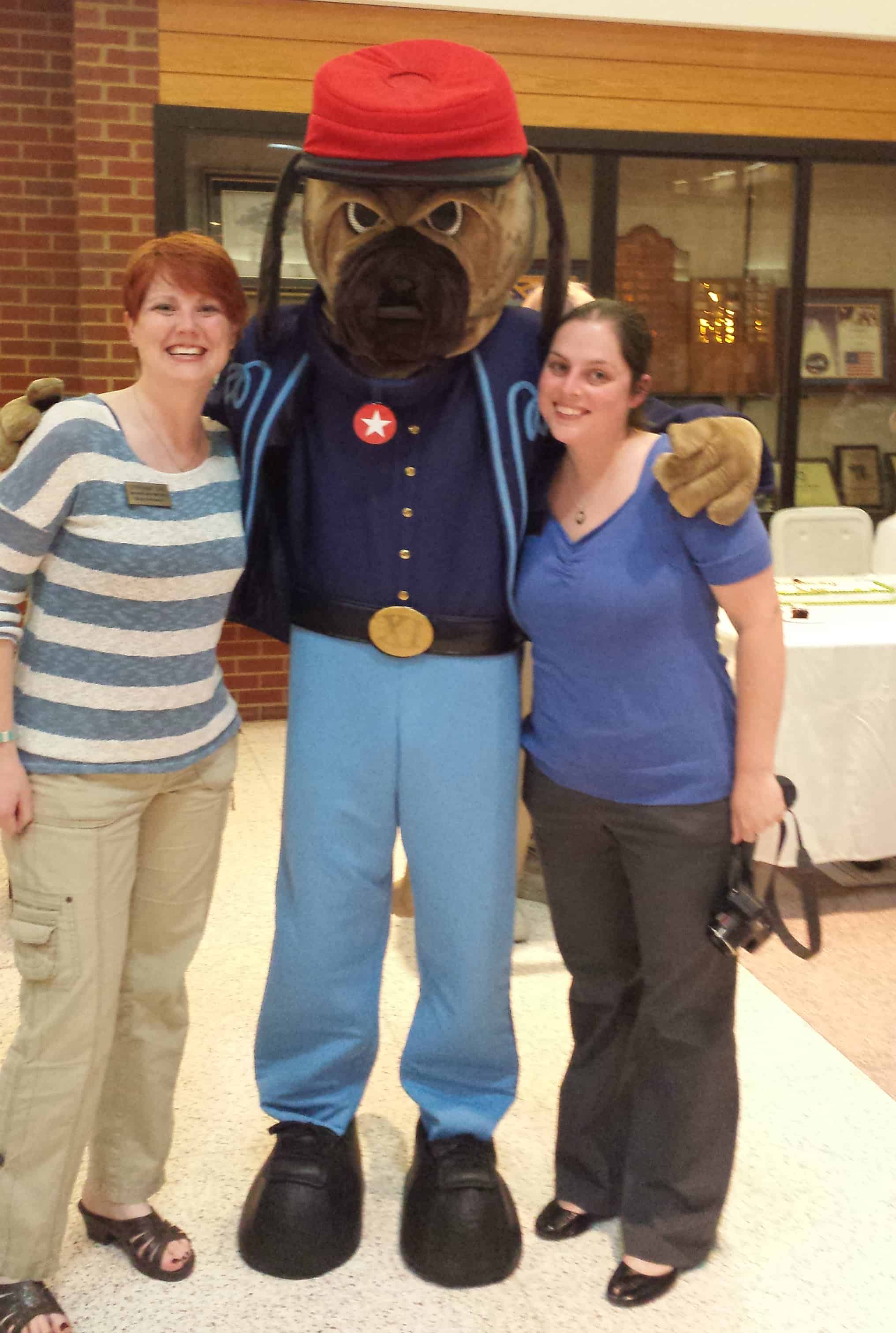 Visitor Services Coordinator Stephanie Cain and Associate Director Amanda McGuire pose with Zeke, the Indy Eleven's Zouave-uniform-clad mascot