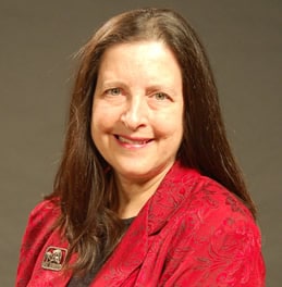 Professor Jane E. Schultz, a white woman with long brown hair. She wears a red shirt.
