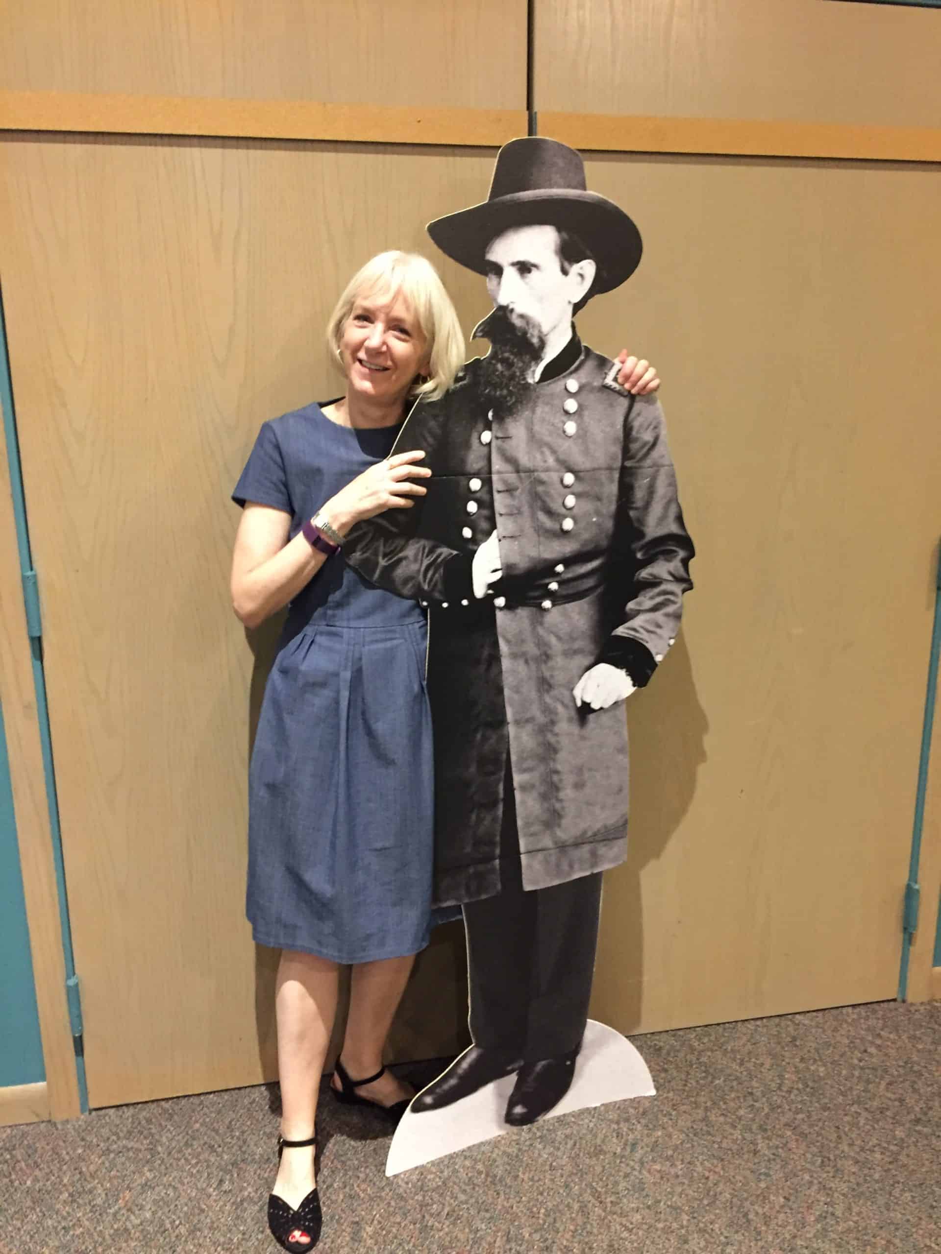 Carol Wallace, a blonde woman, stands next to a life-size cardboard cutout of her great-great-grandfather, Lew Wallace.