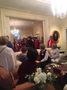 A room full of women listening to a men's choir singing
