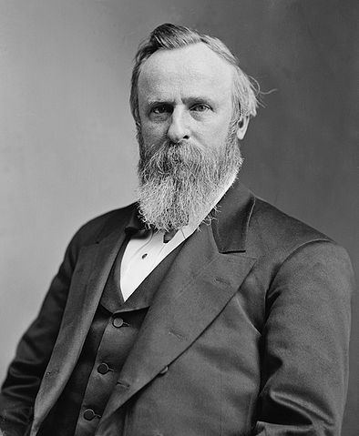 Portrait of President Rutherford B. Hayes; he has a long beard and is seated.