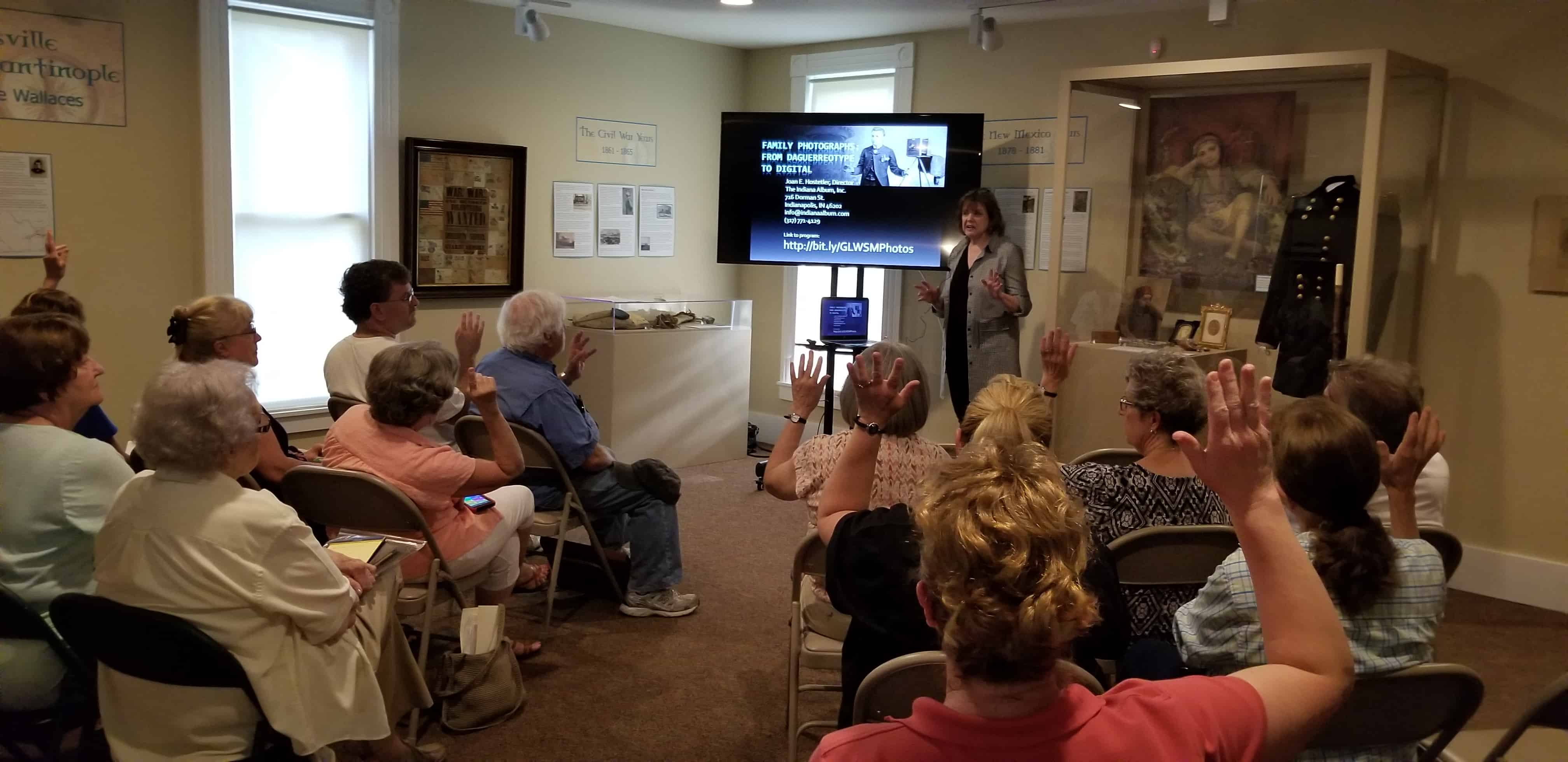 Joan Hostetler gives an historic photo lecture to a group in the Carriage House