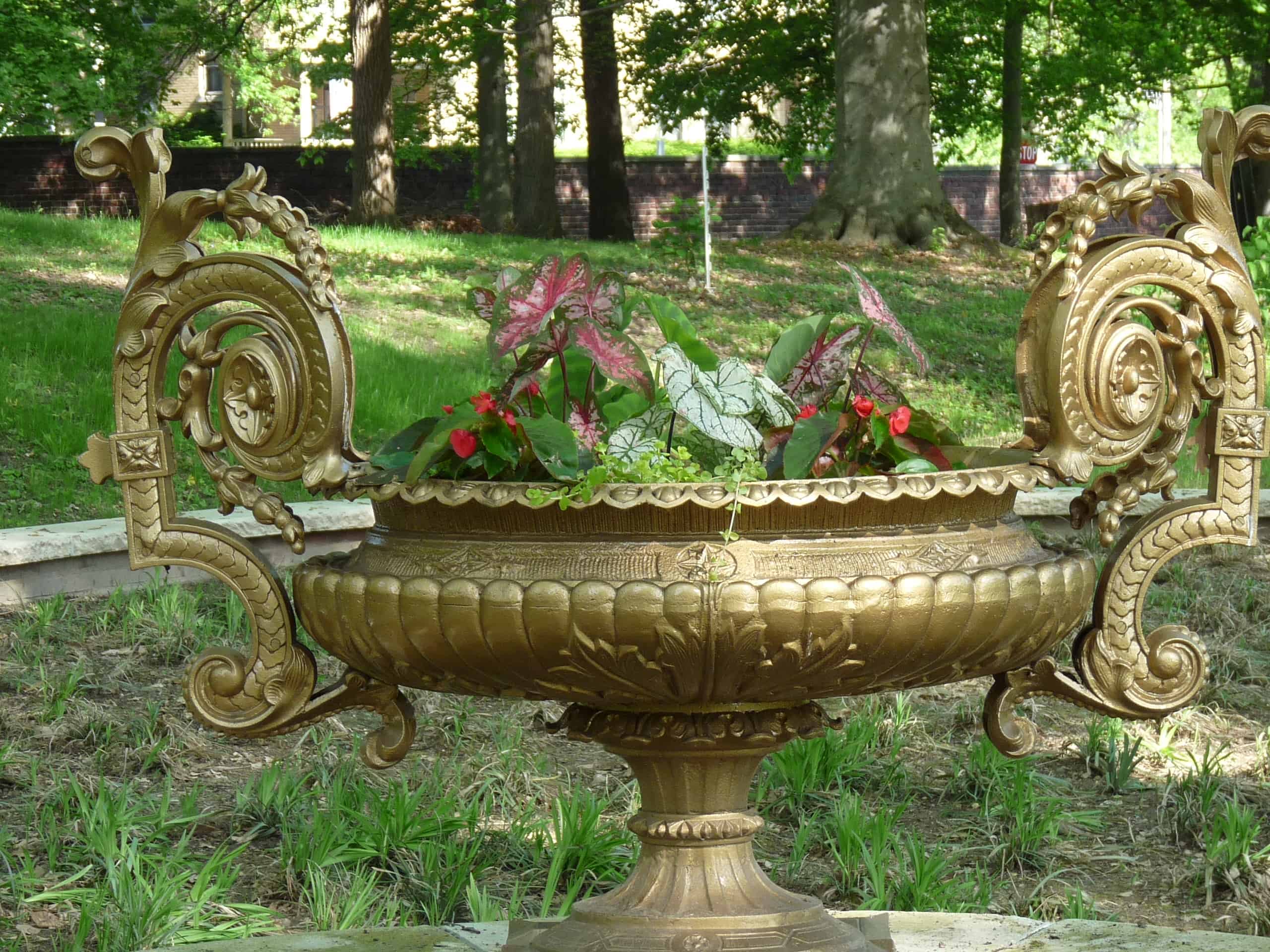 A golden decorative urn planted with flowers