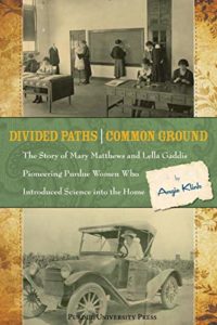 The cover of Divided Paths, Common Ground by Angie Klink. The cover shows several women standing at a chalkboard. Below the picture is the title. Below the title is an old-time automobile.